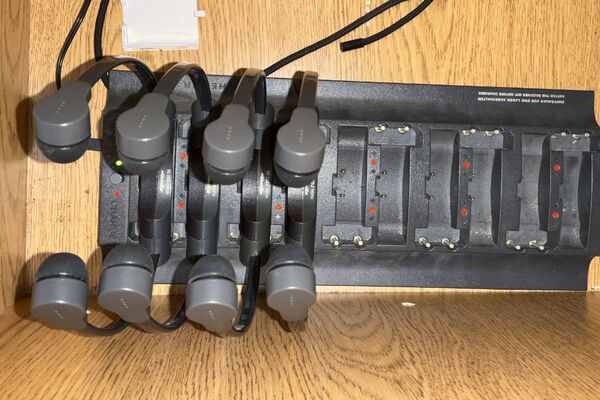 Pedestal - inside view of drawer showing wireless mics in charging base and assistive listening devices in charger