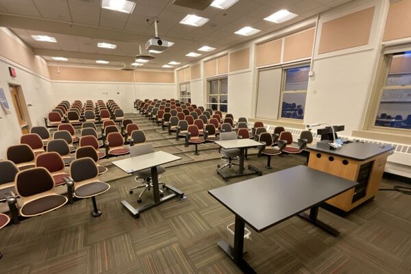 Back of room view of student auditorium seating and and exit door at left side of room