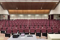 Back of room view of student auditorium seating and exit door at right rear of room