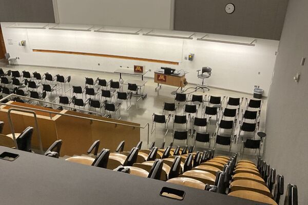 Front of room view with lectern on right in front of markerboard and projection screen above