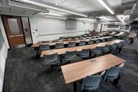 Front of room view with lectern center in front of markerboard, exit on right