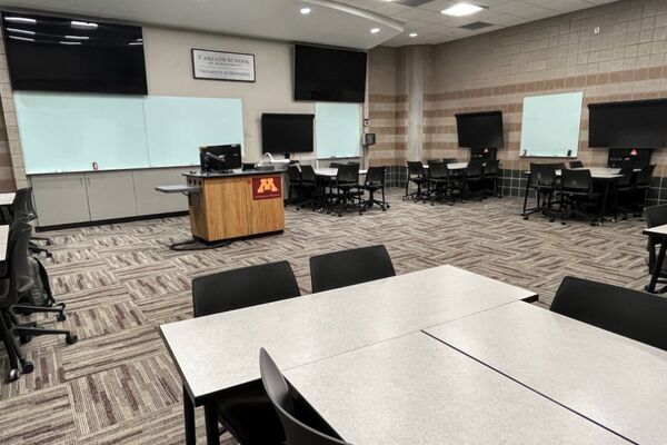 View with lectern center in front of markerboards and display screens behind and above