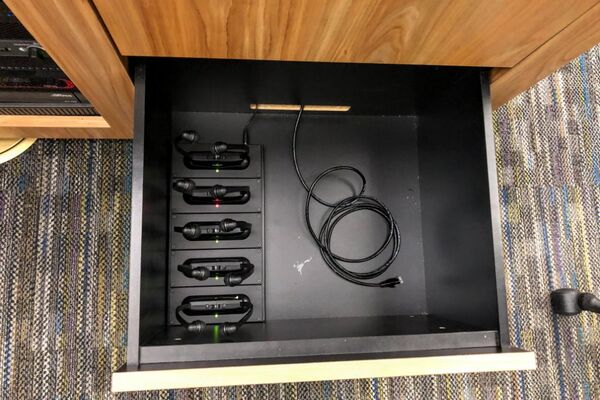 Pedestal - inside view of drawer showing assistive listening devices in charging base