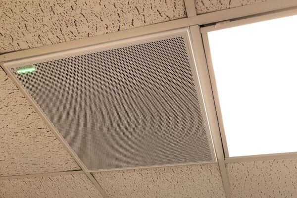 White 2¿ x 2¿ tile mounted in the ceiling to provide microphone coverage over student seating