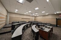 Back of room view of student tiered fixed-table and chair seating 