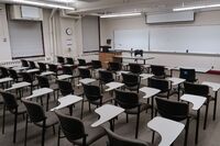 Front of room view with lectern on left in front of markerboard 