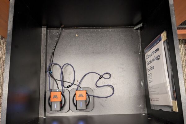 Pedestal - inside view of drawer showing two wireless mics in charging base