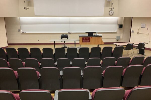 Front of room view with lectern on right in front of markerboard and projection area above