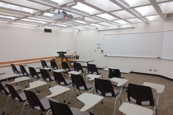 Front of room view with lectern on left and projection screen fully raised