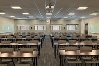 Back of room view of student table and chair seating, exit on right wall