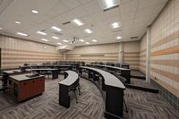 Back of room view of student tiered fixed-table and chairs seating 