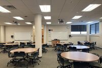 View of room with lectern center in front of markerboards 