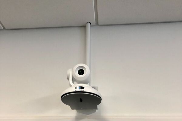 Camera mounted to a wall and instructor enabled adjustments to the lens to allow the instructor to be "seen" by the camera in more locations around the room