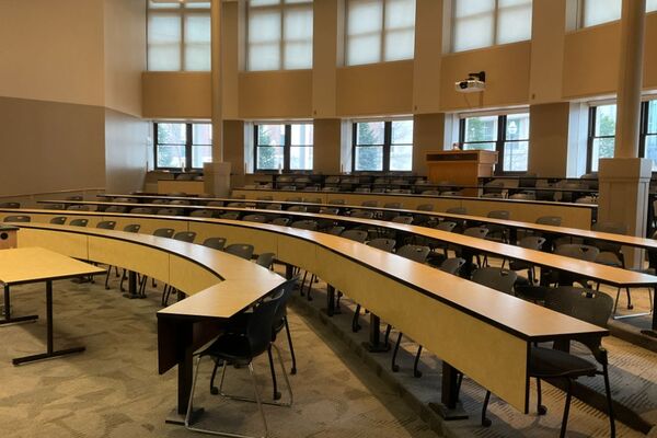 Back of room view of tiered auditorium with tables and chairs