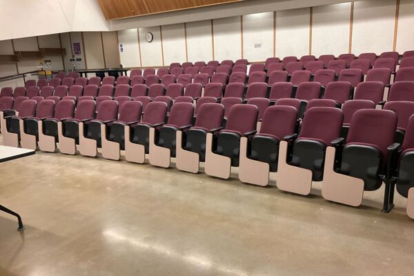 Back of room view of student auditorium seating with exit doors at rear of room