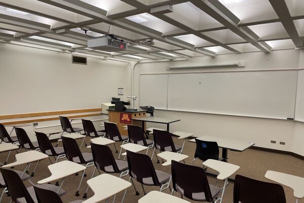 Front of room view with lectern on left and projection screen fully raised