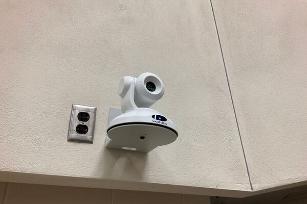 Camera mounted to a wall and instructor enabled adjustments to the lens to allow the instructor to be "seen" by the camera in more locations around the room