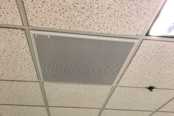 White 2¿ x 2¿ tile mounted in the ceiling to provide microphone coverage over student seating