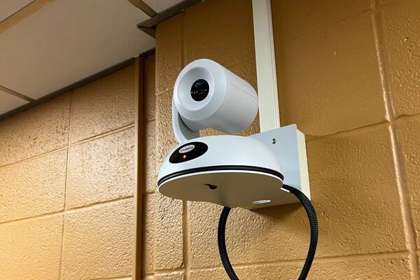 Camera mounted to a wall and instructor enabled adjustments to the lens to allow the instructor to be "seen" by the camera in more locations around the room